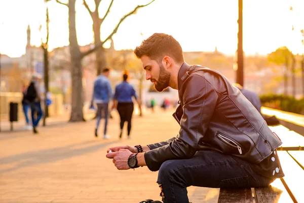 Jovem Hipster Bonito Sentado Banco Pôr Sol Usando Seu Smartphone — Fotografia de Stock