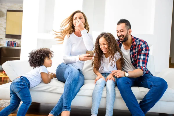 Una Joven Familia Raza Mixta Sentada Sofá Divirtiéndose Con Smartphone — Foto de Stock