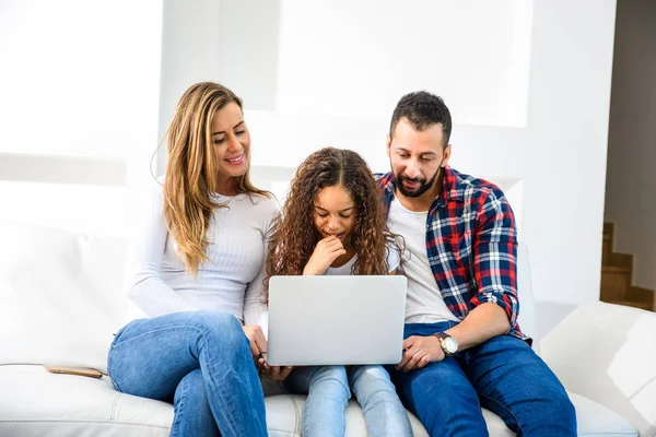 Jovens Pais Sentados Sofá Com Filha Usando Laptop — Fotografia de Stock