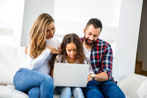 Padres Jóvenes Sentados Sofá Con Hija Usando Portátil — Foto de Stock