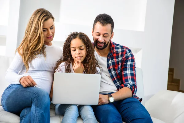 Jovens Pais Sentados Sofá Com Filha Usando Laptop — Fotografia de Stock