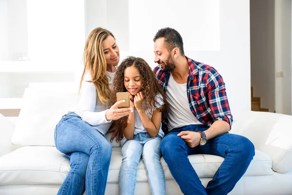 Jovens Pais Sentados Sofá Com Sua Filha Todos Eles Olhando — Fotografia de Stock