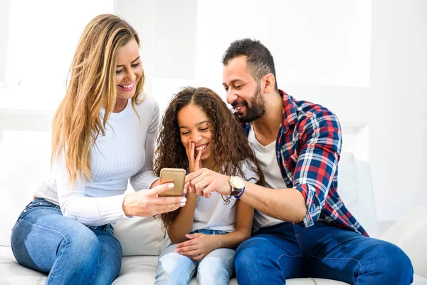 Jovens Pais Sentados Sofá Com Sua Filha Todos Eles Olhando — Fotografia de Stock