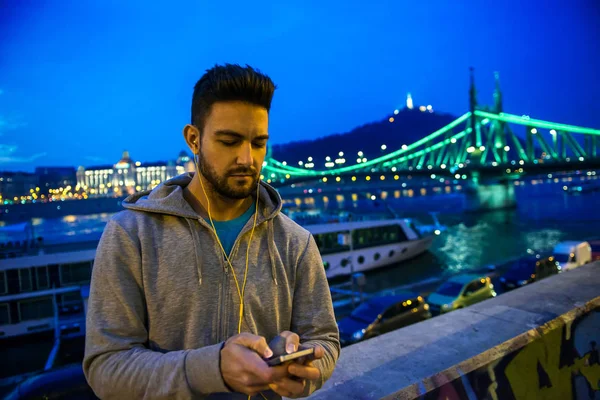 Beau Jeune Sportif Utilisant Son Téléphone Debout Dans Les Lumières — Photo