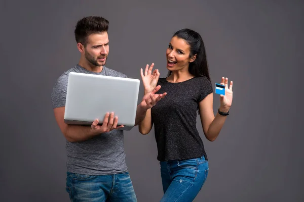 Jovem Bonito Segurando Laptop Enquanto Sua Namorada Mostrando Cartão Crédito — Fotografia de Stock