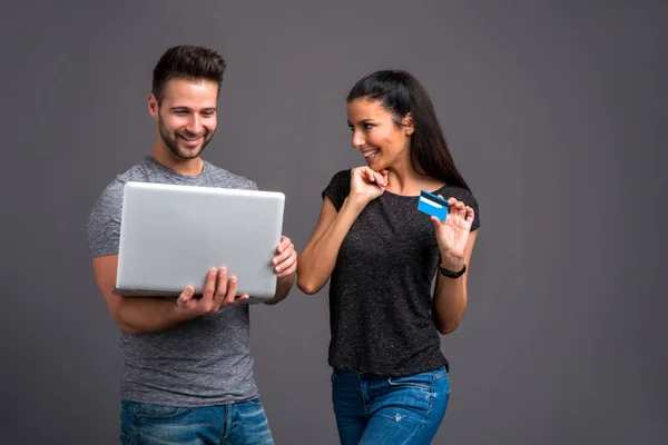 Jovem Bonito Segurando Laptop Enquanto Sua Namorada Mostrando Cartão Crédito — Fotografia de Stock