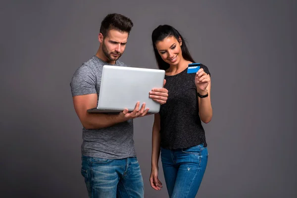 Jovem Bonito Segurando Laptop Enquanto Sua Namorada Mostrando Cartão Crédito — Fotografia de Stock