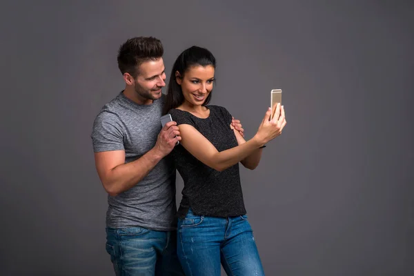 Una Bella Giovane Coppia Selfie Con Uno Smartphone Studio — Foto Stock