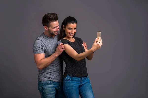 Una Hermosa Pareja Joven Tomando Una Selfie Con Smartphone Estudio —  Fotos de Stock