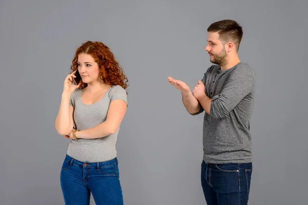 Una Hermosa Joven Pie Hablando Por Teléfono Ignorando Guapo Novio — Foto de Stock