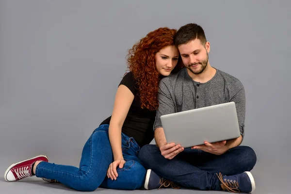 Una Hermosa Pareja Joven Sentada Suelo Mirando Ordenador Portátil Sonriendo —  Fotos de Stock