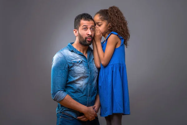 彼女は彼の耳にささやく彼の十代の娘の横に折り敷き若い黒人男性 — ストック写真