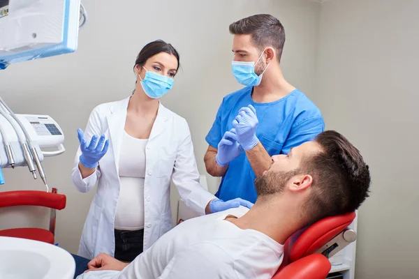 Стоматолог и ассистент с пациентом — стоковое фото