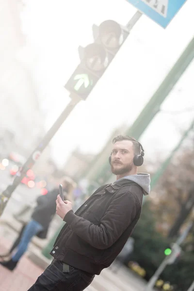 Hipster hombre comprobar el teléfono inteligente en un paso de peatones — Foto de Stock