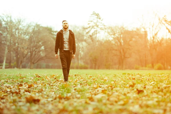 Foto de estilo retro de un hombre hipster caminando por el parque — Foto de Stock