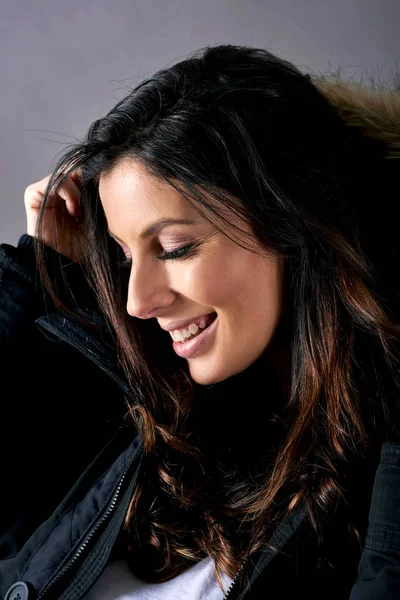 En ung glad kvinna i en svart kappa — Stockfoto