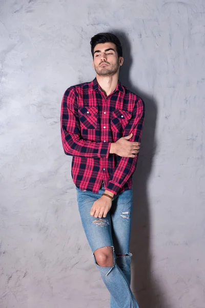 A serious young man in a red checkered shirt — Stock Photo, Image