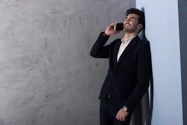 Un giovane uomo d'affari felice che parla al telefono con un completo — Foto Stock