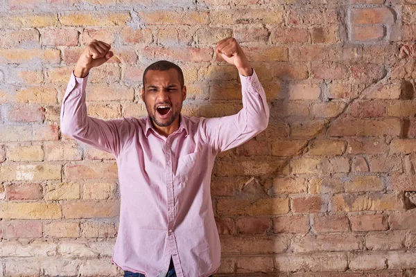 Cheering man in a pink shirt — Stock Photo, Image