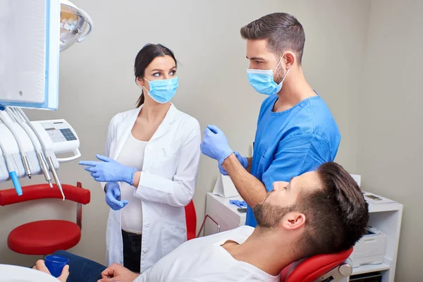 Un dentiste et un assistant avec le patient — Photo