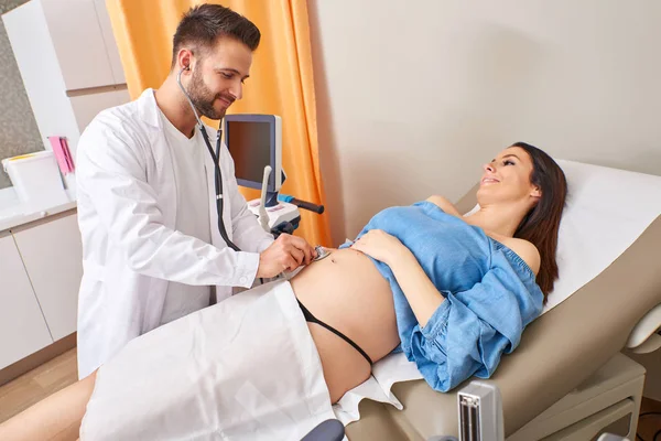 Onderzoek van een zwangere vrouw met een stethoscoop — Stockfoto