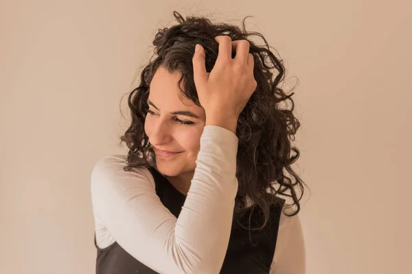 Een lachende vrouw speelt met haar haren — Stockfoto