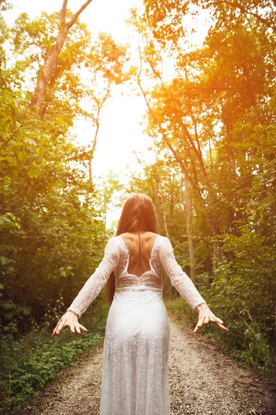 Eine Frau steht im Wald und zeigt ihr den Rücken — Stockfoto