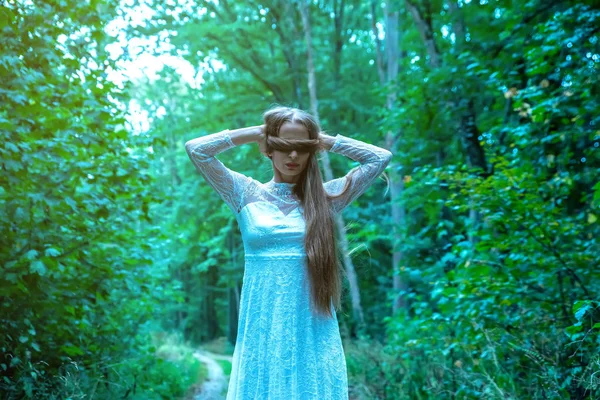 Una mujer en el bosque cubriéndose los ojos con su pelo — Foto de Stock