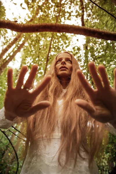 Eine Frau steht im Wald und zeigt ihre Hände — Stockfoto