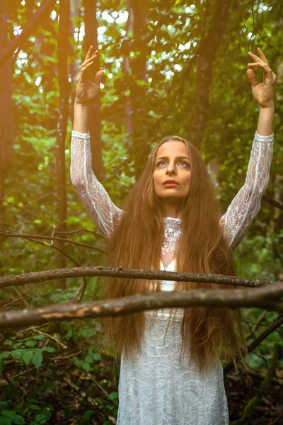 Eine Frau, die im Wald steht und nach oben greift — Stockfoto