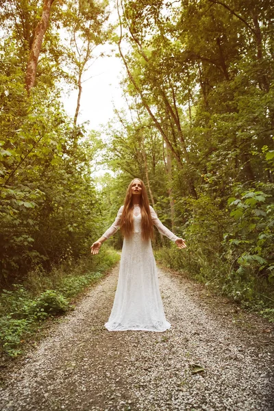 Une femme debout et posant dans la forêt — Photo