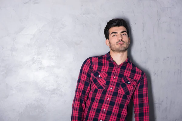 A serious young man in a red checkered shirt — Stock Photo, Image