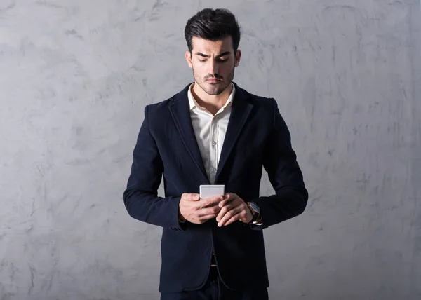 Ένας σοβαρός νέος επιχειρηματίας χρησιμοποιώντας ένα smartphone — Φωτογραφία Αρχείου