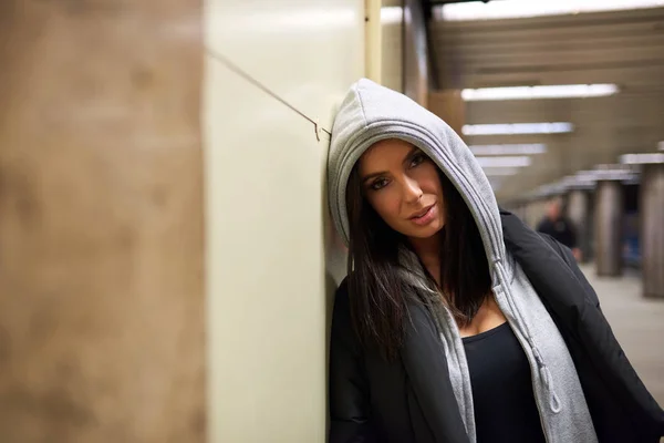 Een serieuze jonge vrouw permanent op een metrostation — Stockfoto