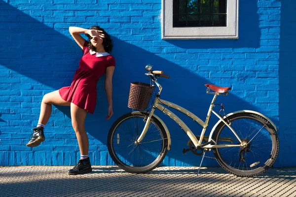 벽돌 벽 앞에서 포즈를 취하는 자전거와 함께 여자 — 스톡 사진