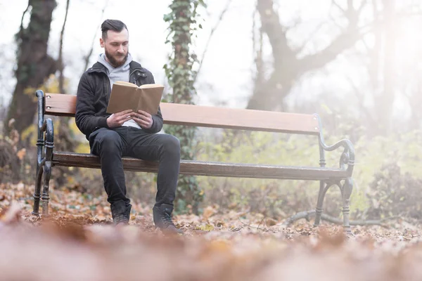Uomo hipster che legge su una panchina — Foto Stock
