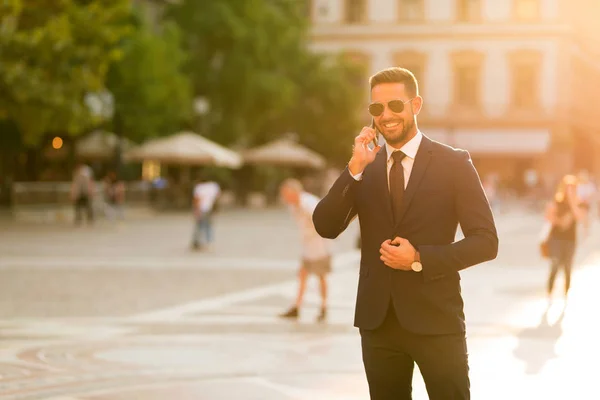 Podnikatel, který chodí a mluví po telefonu. — Stock fotografie