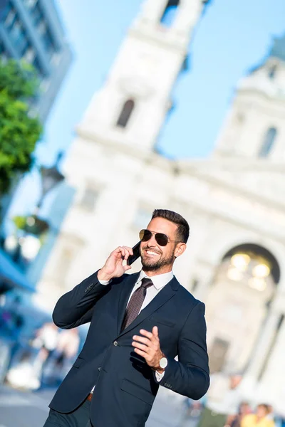 Biznesmen chodzący i mówiący przez telefon — Zdjęcie stockowe