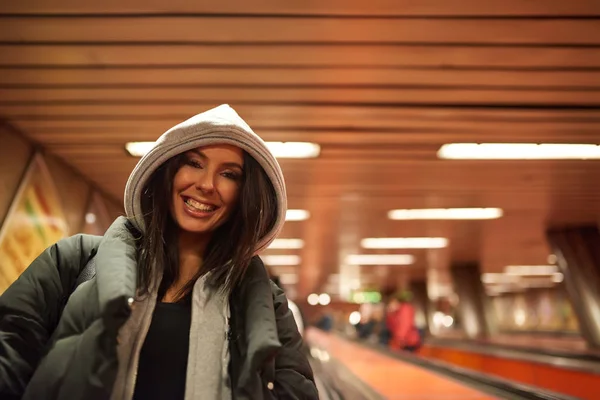 Uma jovem feliz de pé em uma escada rolante — Fotografia de Stock