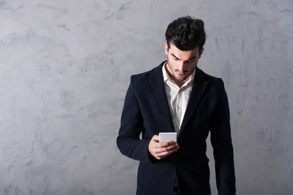 Un joven empresario serio usando un teléfono inteligente — Foto de Stock