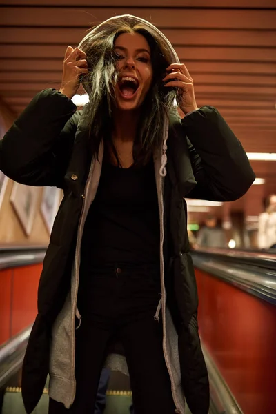 Een gillende jonge vrouw staande op een roltrap — Stockfoto