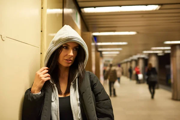 Een serieuze jonge vrouw permanent op een metrostation — Stockfoto