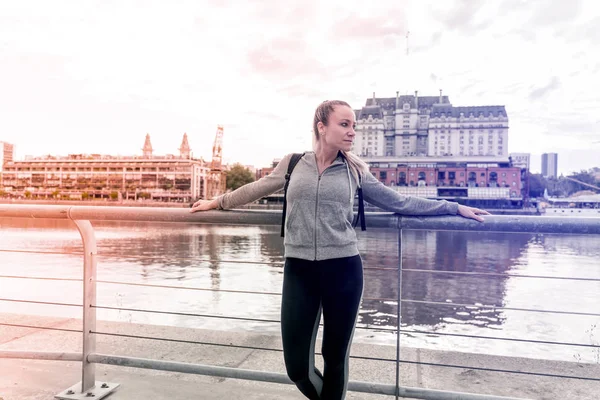 橋の欄干の隣に立ってスポーツの女性 — ストック写真