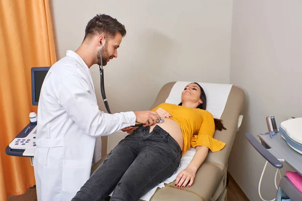 Examinar a una mujer embarazada con un estetoscopio —  Fotos de Stock