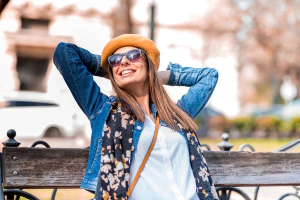 Une jeune femme se relaxant sur un banc — Photo