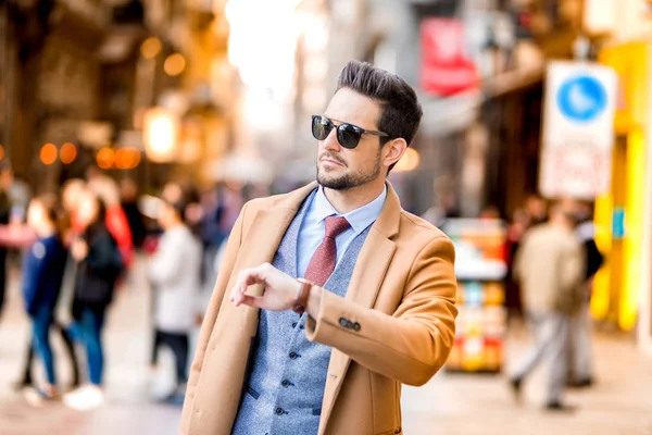 Un uomo elegante che cammina per le strade e controlla l'ora — Foto Stock