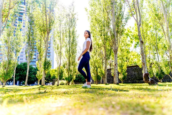 Una giovane donna in posa in un parco in una giornata di sole — Foto Stock