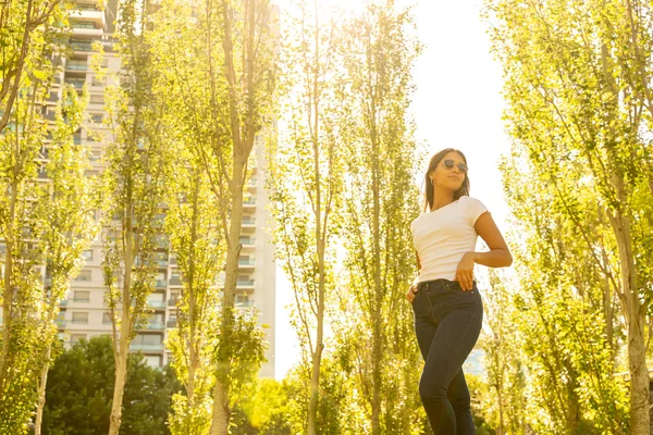 Молодая женщина позирует в парке в солнечный день — стоковое фото