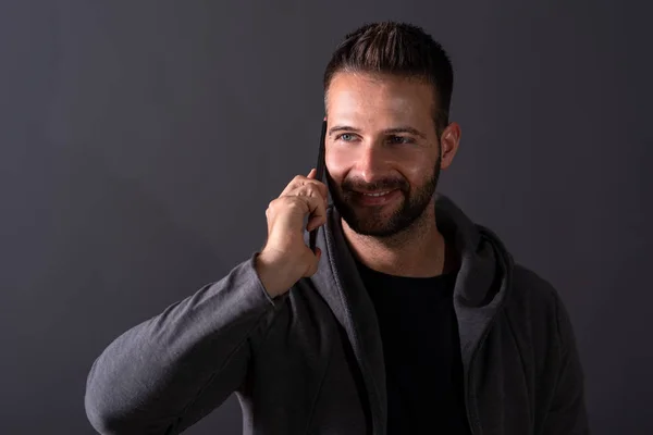 A smiling young man talking on his phone — Stock Photo, Image