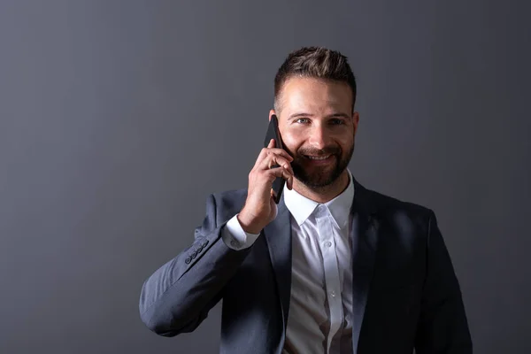 Un hombre de negocios sonriente hablando por teléfono — Foto de Stock